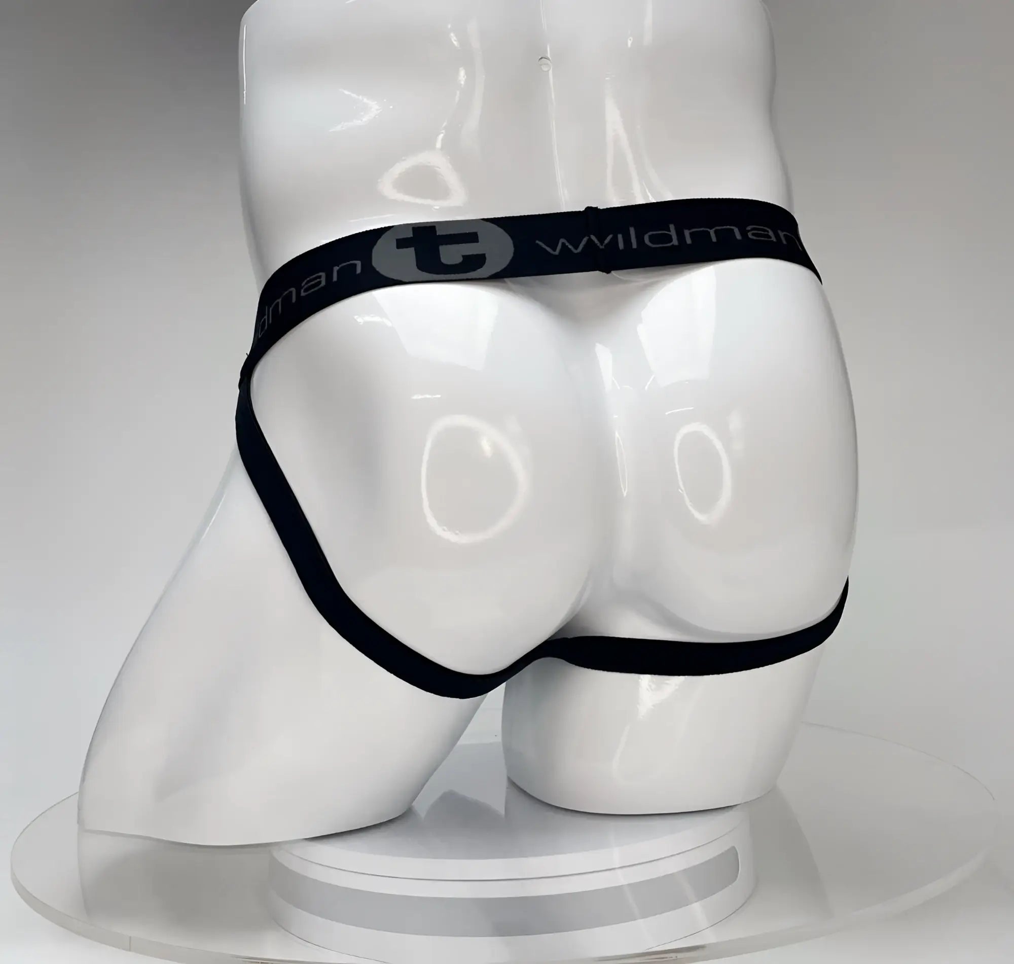 White WildmanT Big Boy jockstrap on a mannequin, featuring a black waistband with the brand name and logo.