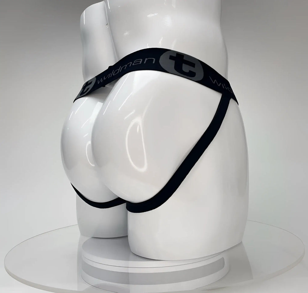 White jockstrap on a mannequin, featuring a black branded waistband with "Wildman" and "T" logo.