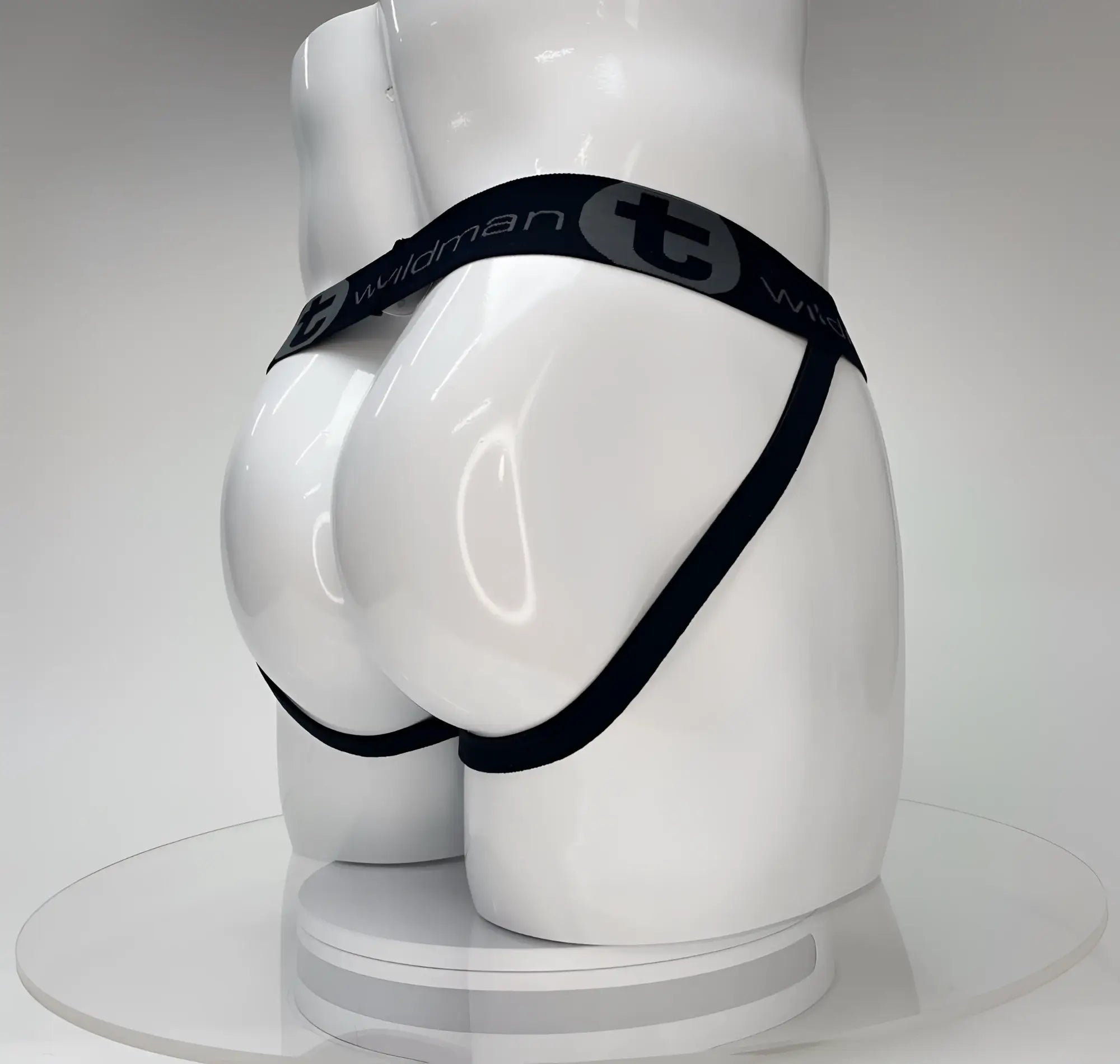 White jockstrap on a mannequin, featuring a black branded waistband with "Wildman" and "T" logo.