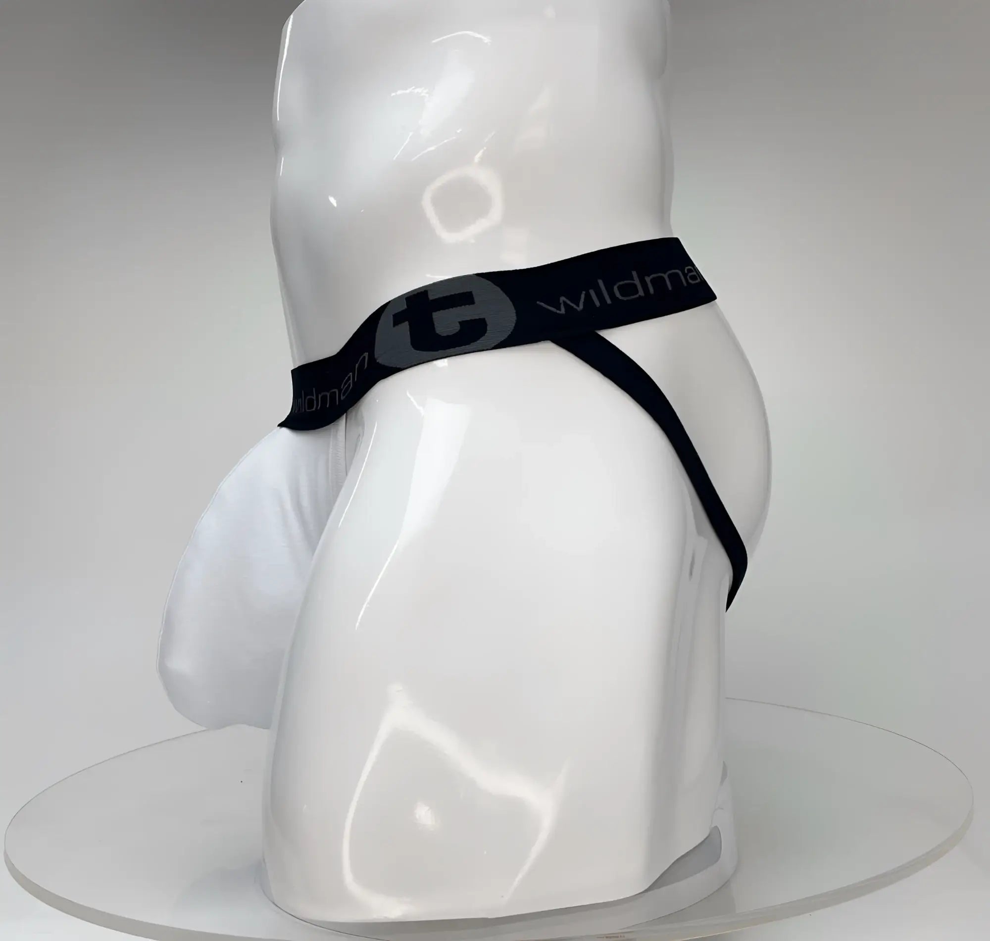 WildmanT Big Boy white jockstrap with a large pouch and black branded elastic waistband on a white mannequin.