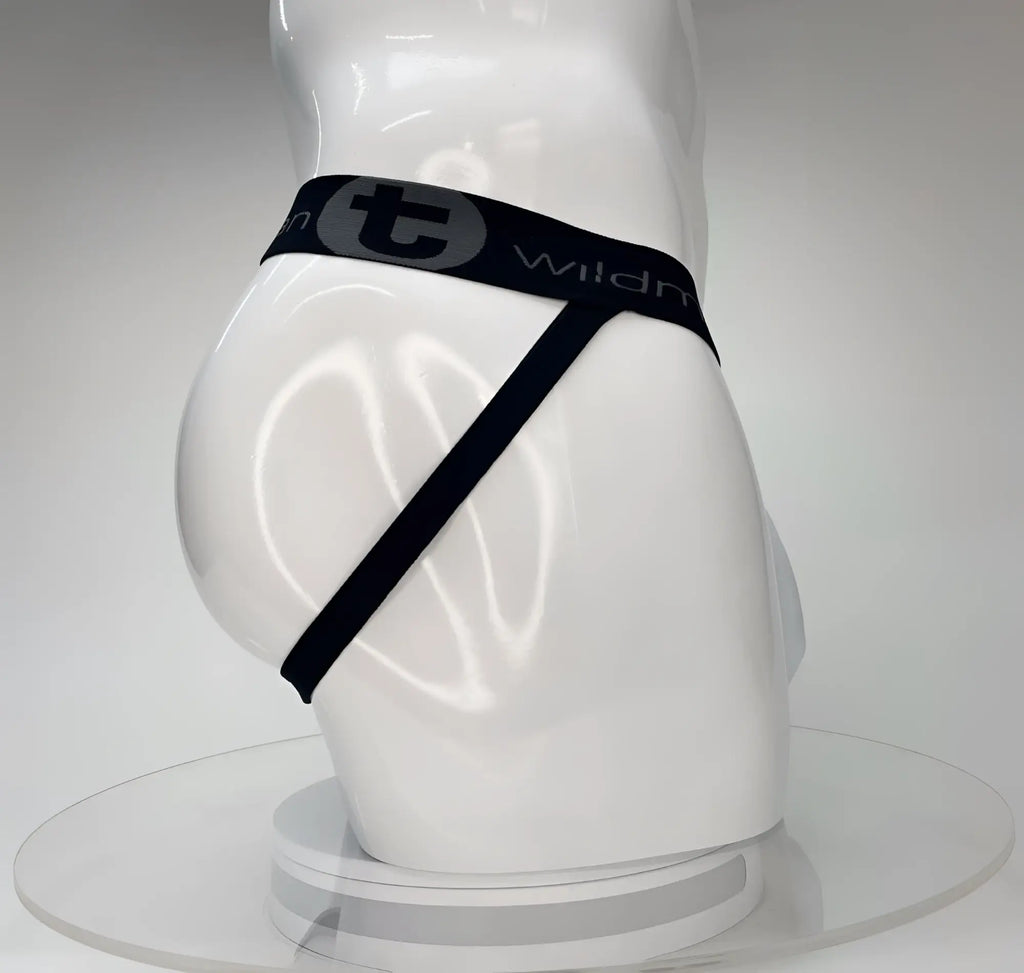 White WildmanT Big Boy jockstrap featuring a black waistband with gray logo text and branding on a white mannequin.