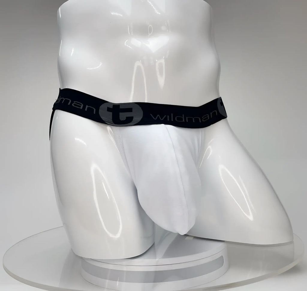 White WildmanT jockstrap with a large front pouch and a black branded elastic waistband on a white mannequin torso.