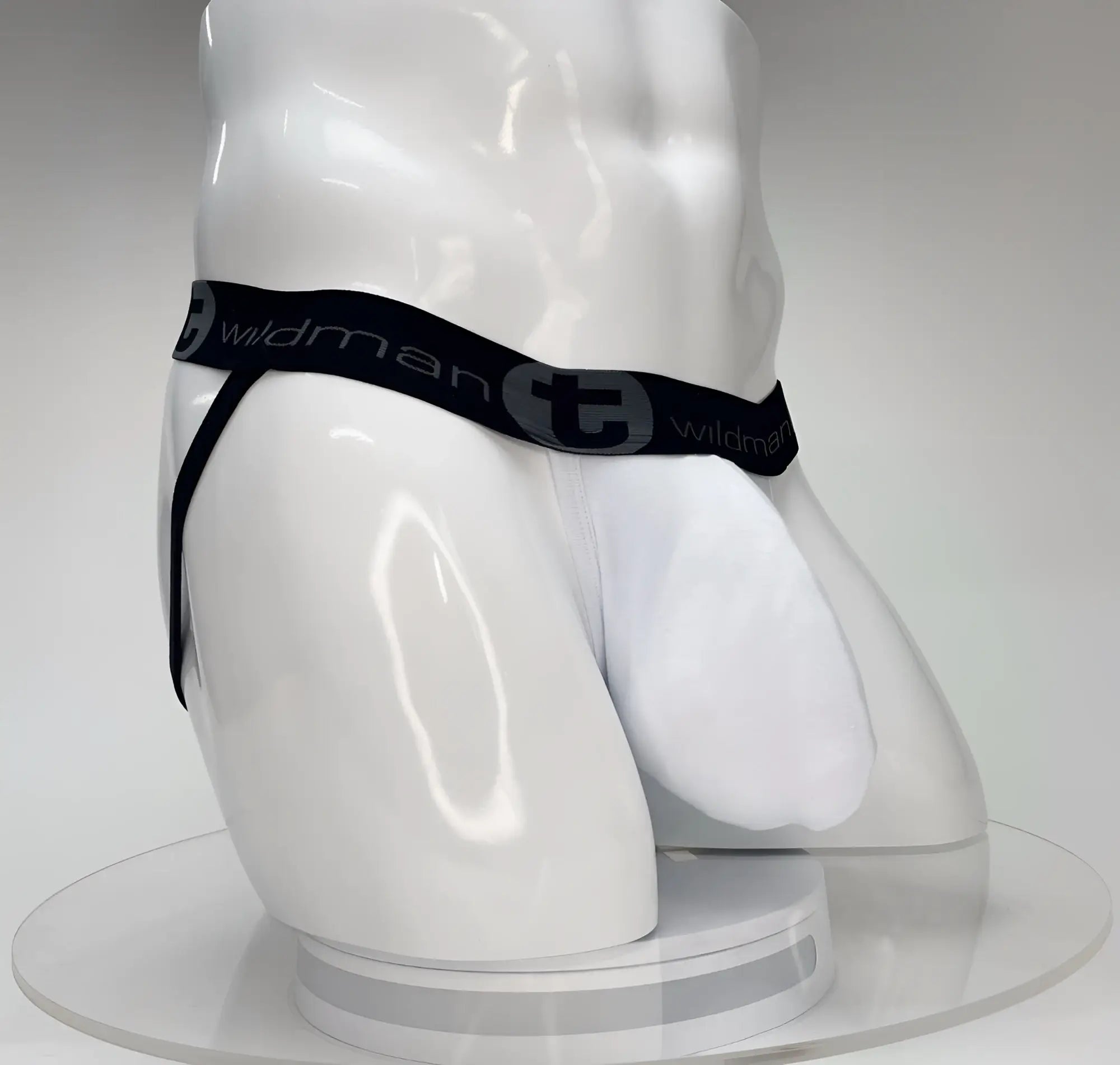 White WildmanT jockstrap with a large front pouch and a black branded waistband on a white mannequin torso.