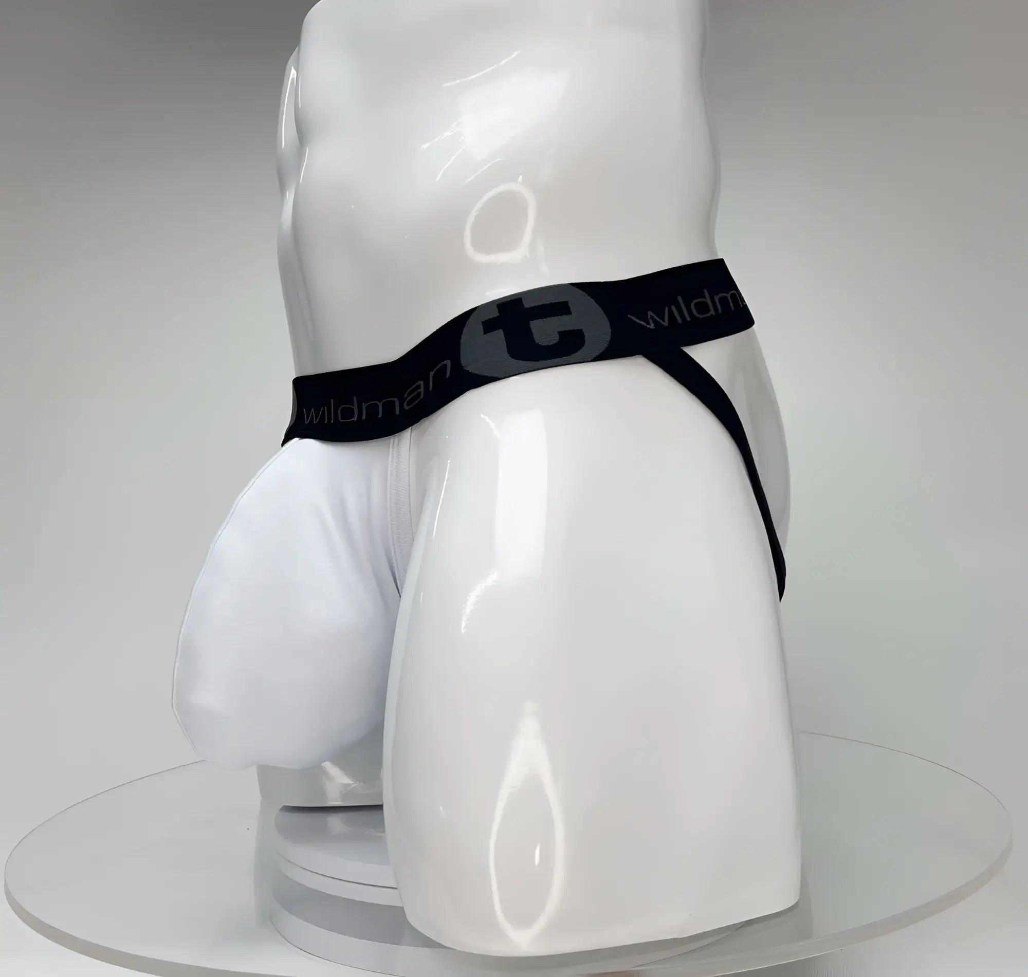 White jockstrap with a large pouch on a white mannequin, featuring a black branded waistband with a WildmanT logo.