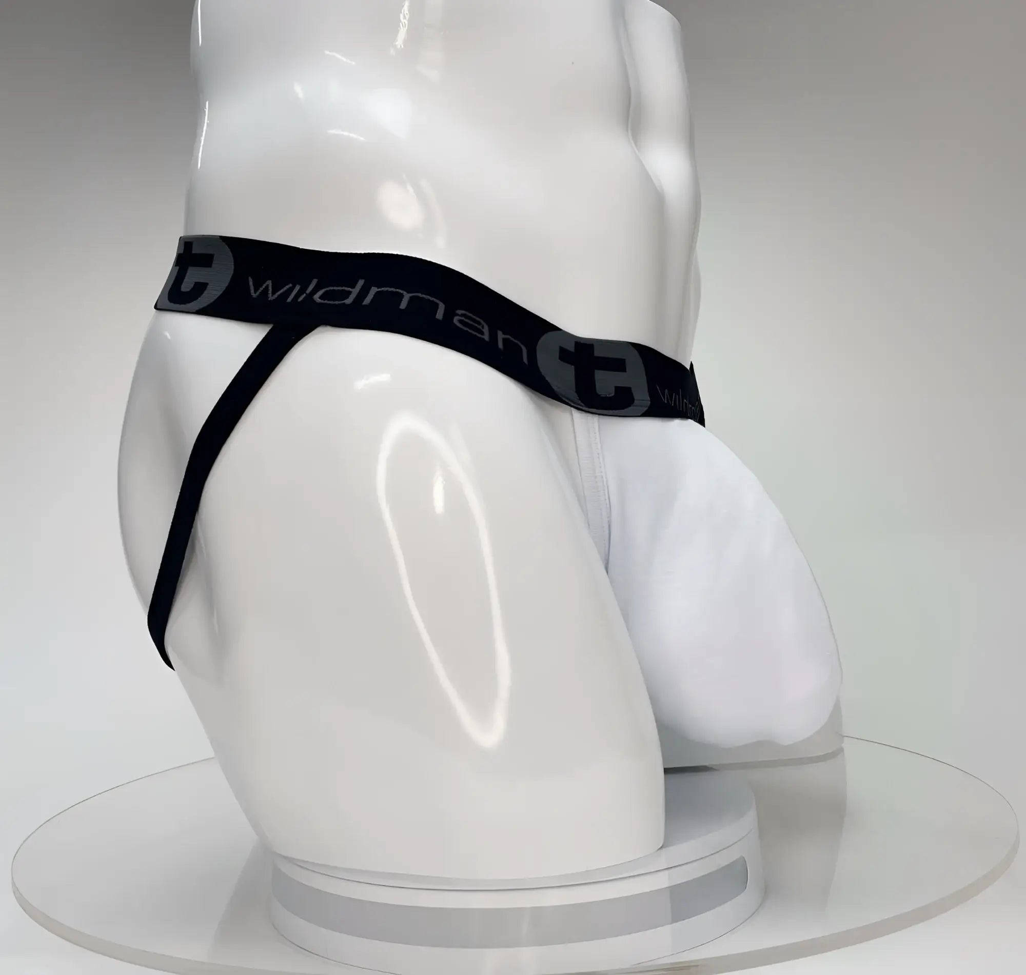 White WildmanT Big Boy pouch jockstrap on a mannequin, featuring a black branded elastic waistband.