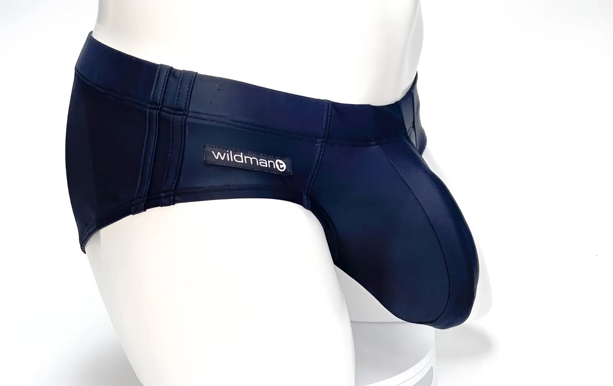 Black WildmanT swim brief on a mannequin, featuring a contoured, prominent pouch and branded side label.