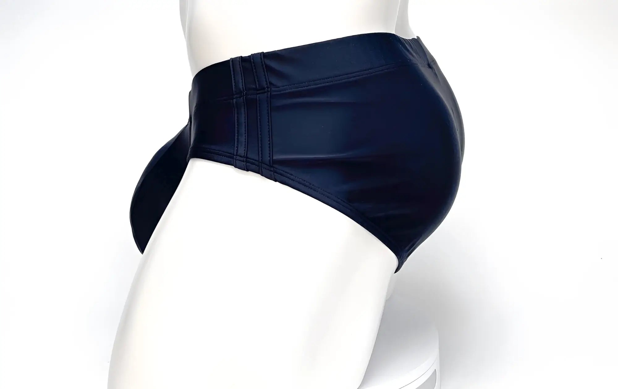 Side view of black WildmanT Big Boy Pouch swim briefs on a mannequin, featuring reinforced side panels.