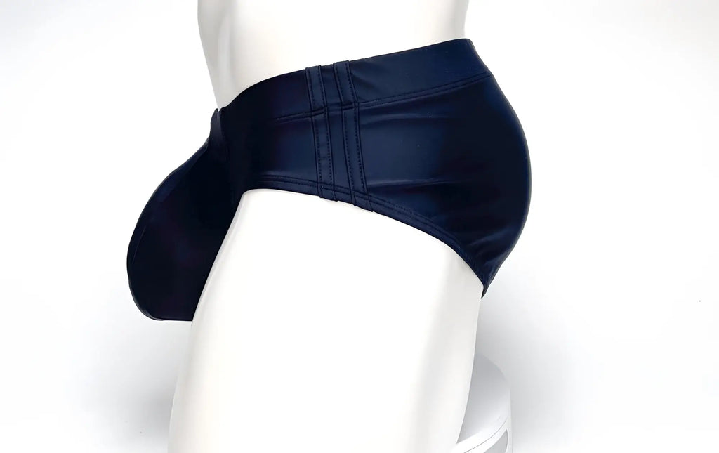 Side view of a black WildmanT Big Boy pouch swim brief on a mannequin, featuring a prominent front pouch and side seams.