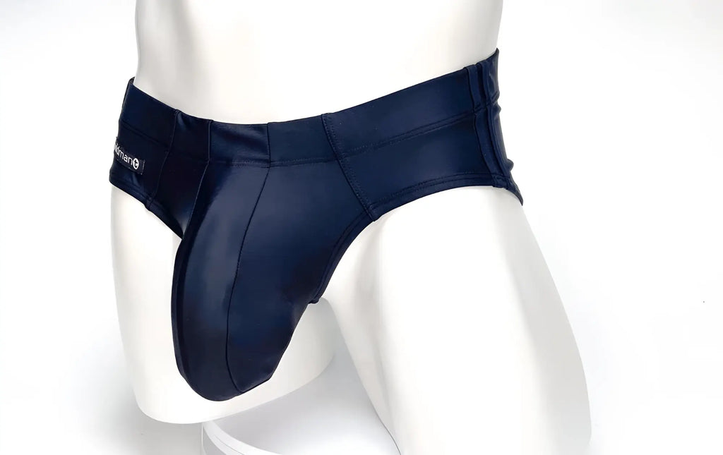 Black WildmanT Big Boy pouch swim brief on a white mannequin with a prominent, contoured front pouch and side tag.