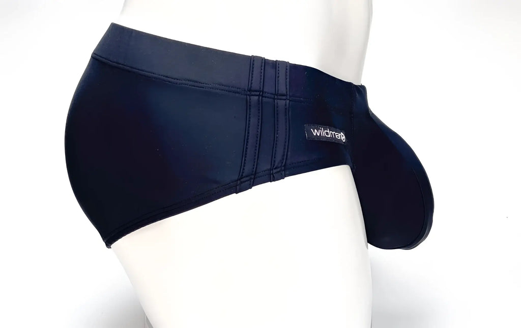 Black WildmanT swim brief with side panels, double-stitch detailing, and a prominent front pouch on a white mannequin.