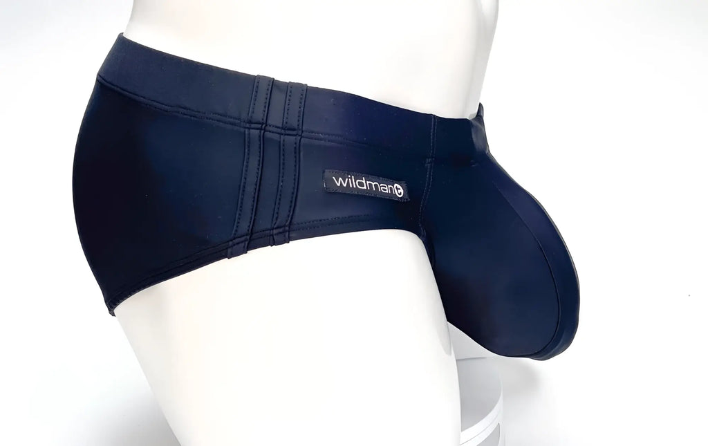 WildmanT black swim brief on a mannequin, featuring a prominent front pouch and side stitching with brand logo tag.