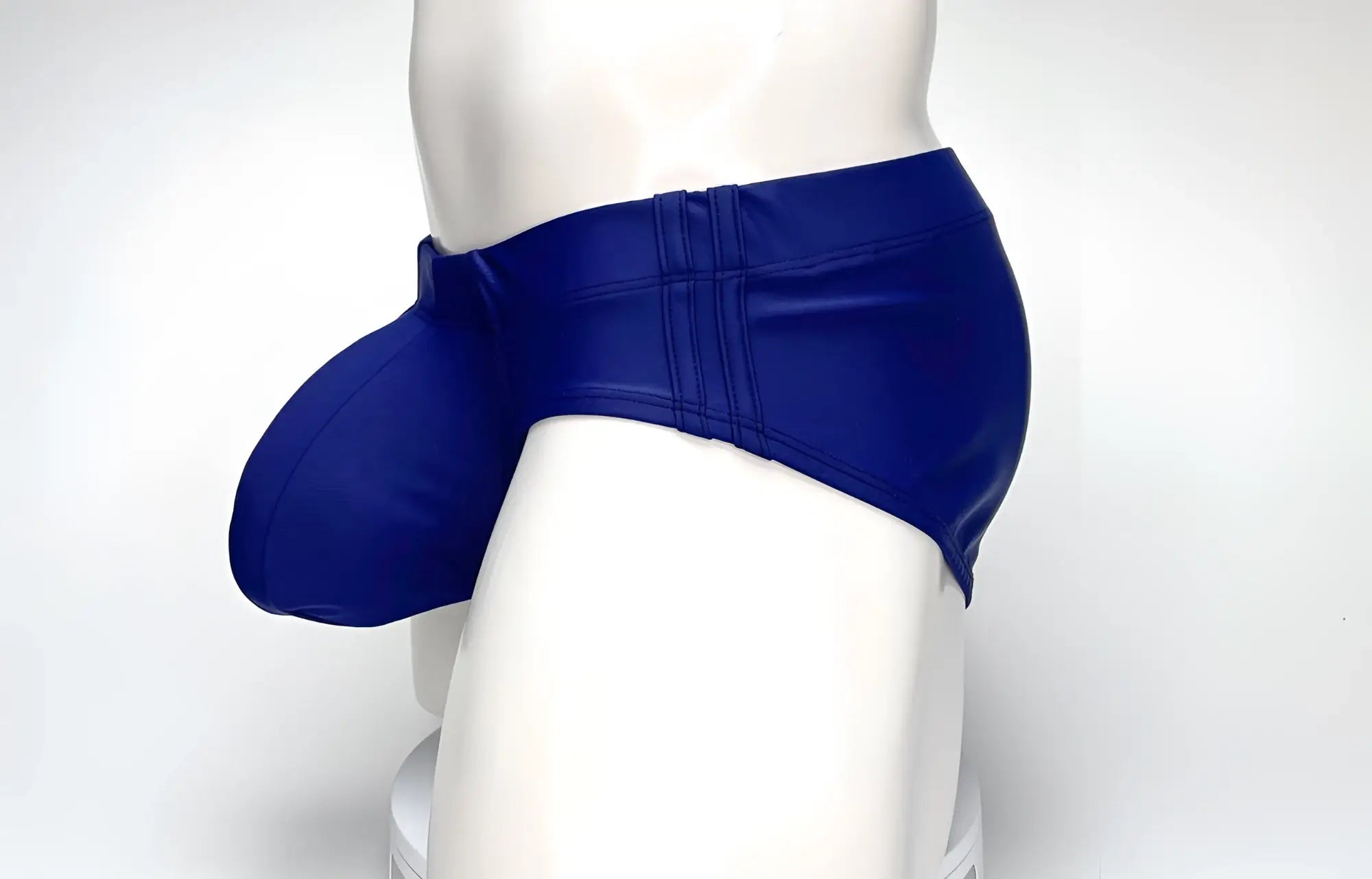 Side view of a navy blue WildmanT Big Boy pouch swim brief on a white mannequin.