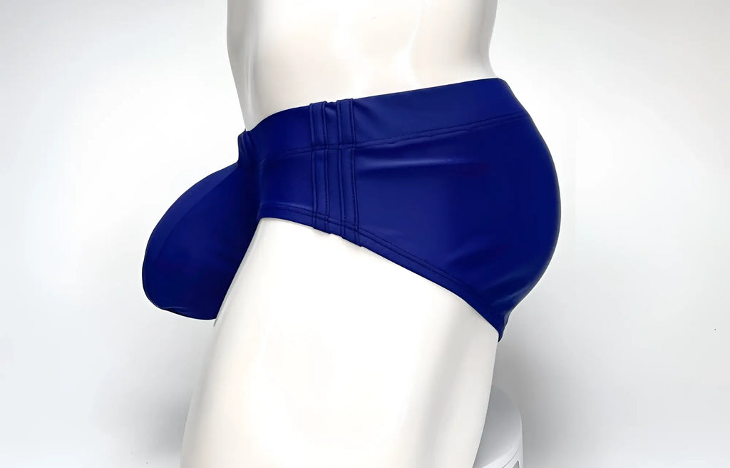 Side view of a navy WildmanT Big Boy Pouch swim brief on a mannequin, highlighting the prominent contoured front pouch.