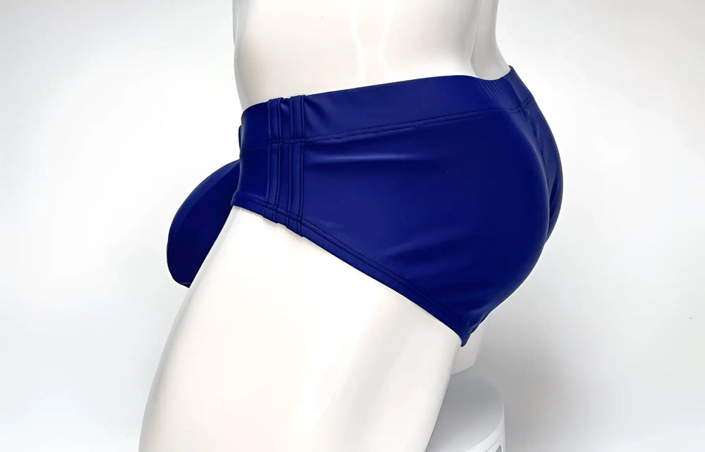 Side view of a navy blue WildmanT Big Boy pouch swim brief on a white mannequin.