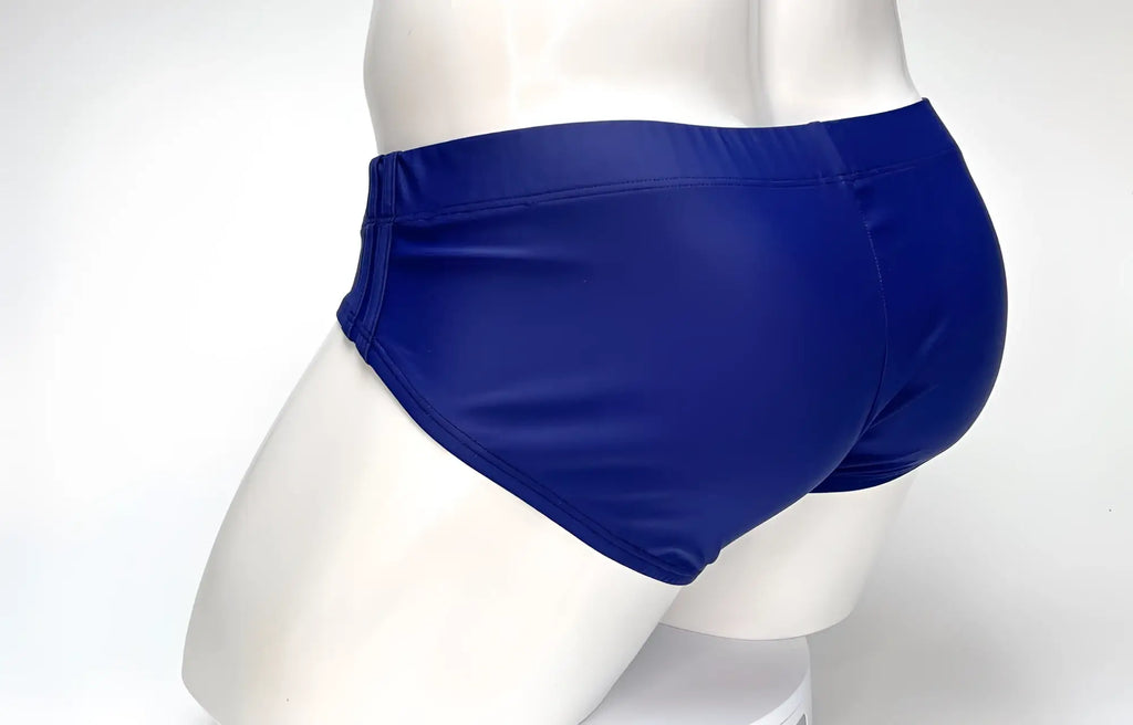 Rear view of a navy blue WildmanT Big Boy Pouch swim brief on a white mannequin.