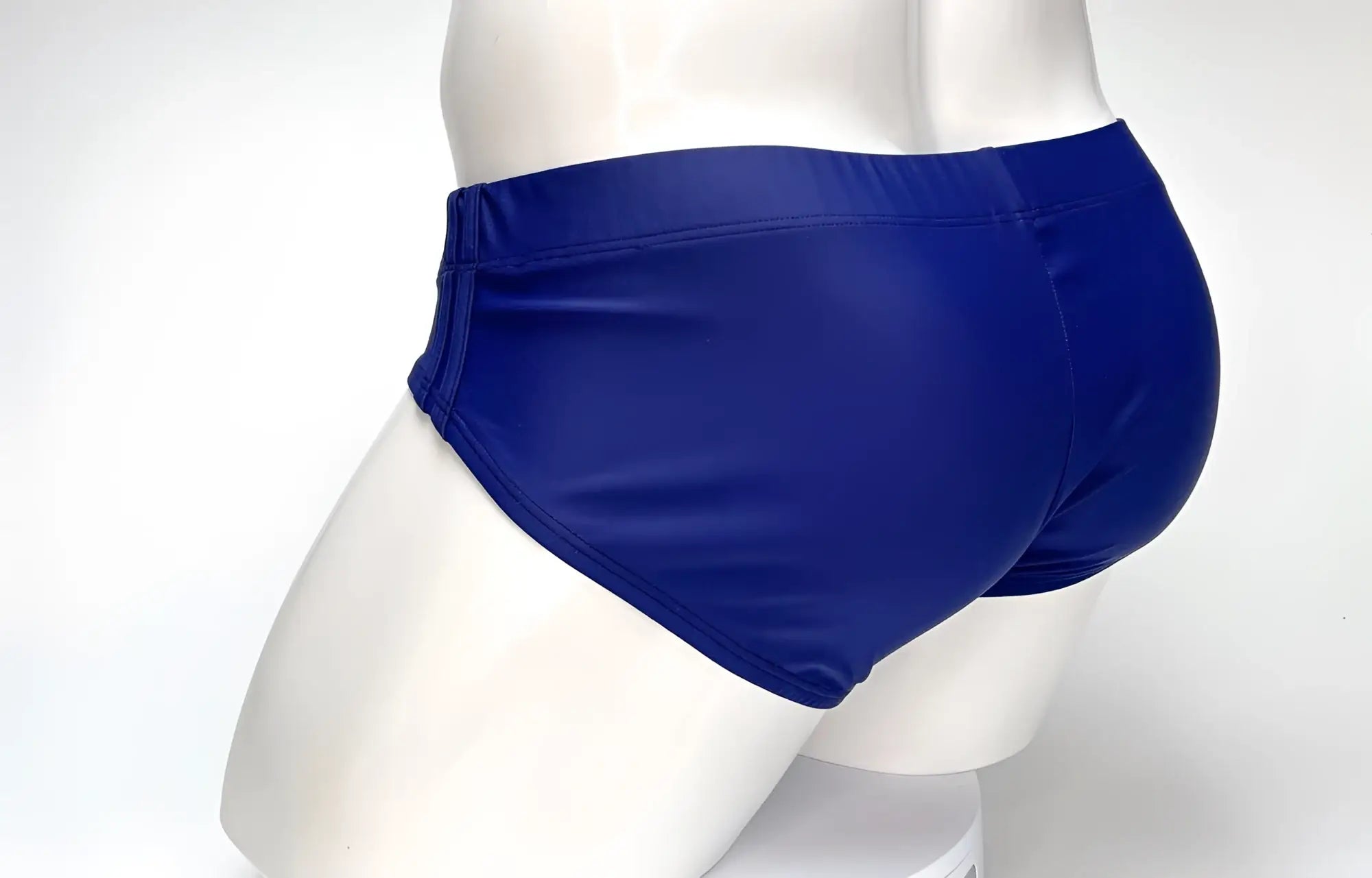 Rear view of a navy blue WildmanT Big Boy Pouch swim brief on a white mannequin.