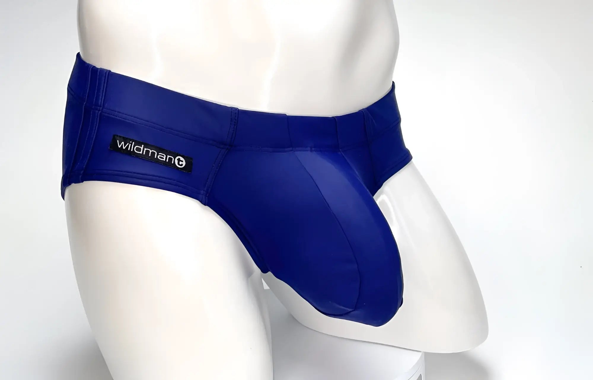 WildmanT navy blue swim brief featuring a prominent, contoured front pouch and a branded logo tag on the side.
