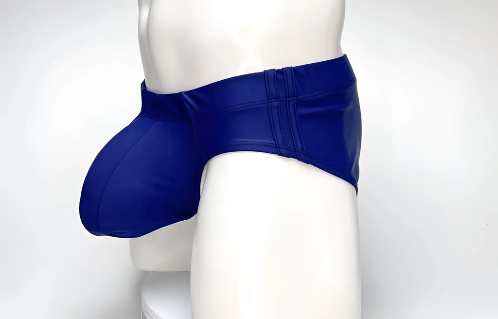 WildmanT navy blue swim brief featuring a prominent, rounded front pouch and contoured side panels on a mannequin.