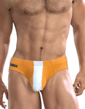 WildmanT Big Boy Pouch swim brief in orange with a vertical white front panel and black logo tag on the side.