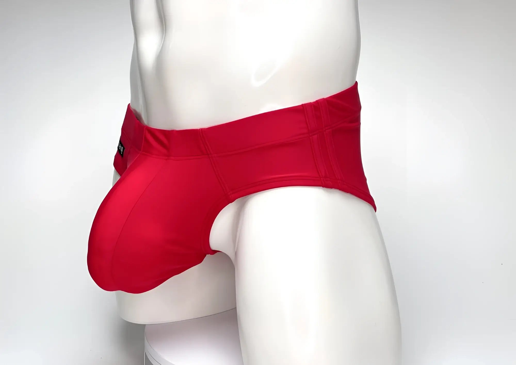 WildmanT Big Boy red swim brief featuring a prominent, spacious front pouch worn on a white mannequin torso.