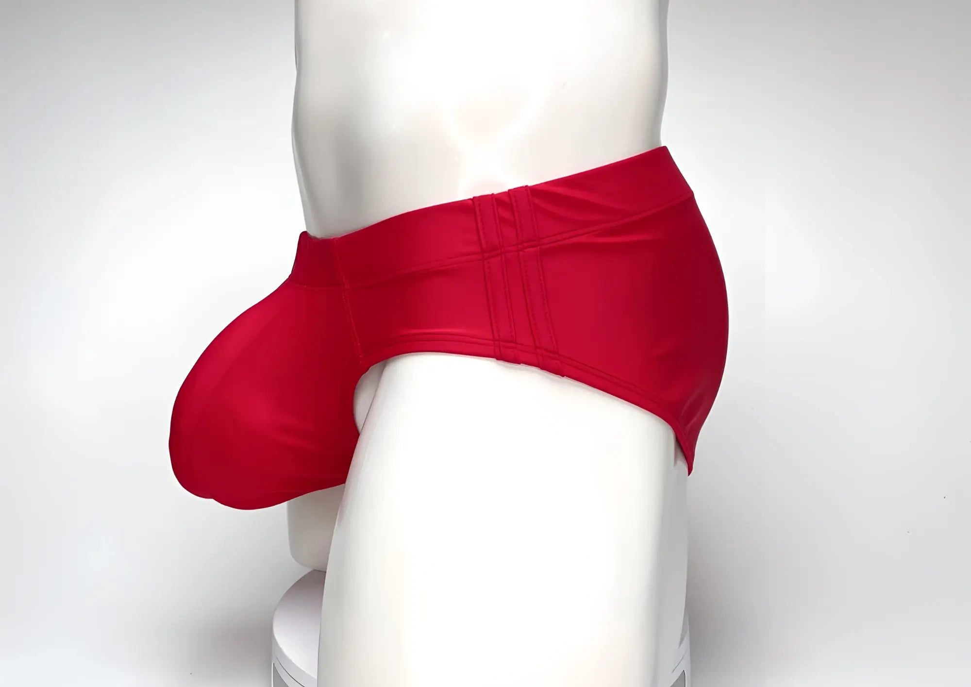 WildmanT Big Boy red swim brief featuring a prominent, rounded front pouch and side-stitched waistband on a mannequin.