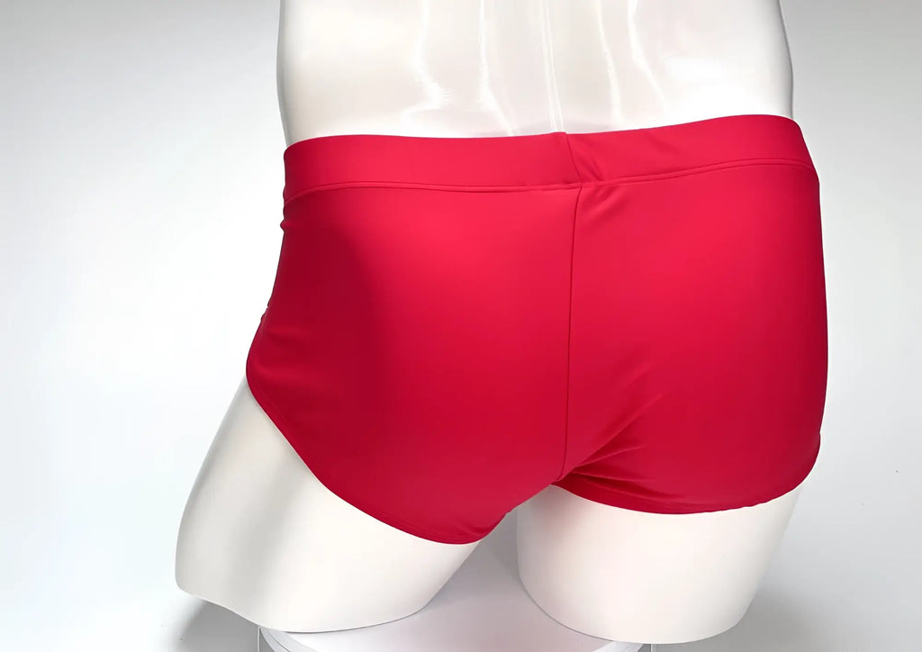 Rear view of a WildmanT Big Boy Pouch swim brief in solid red on a white mannequin torso.