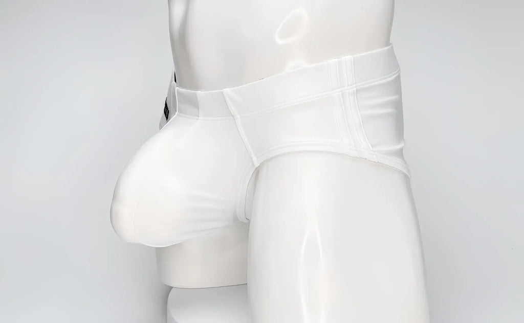 WildmanT white swim brief on a mannequin, featuring a large contoured front pouch and structured waistband.