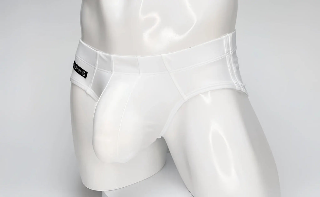 White WildmanT swim brief with a large contoured front pouch, worn by a mannequin, featuring a black side logo tag.