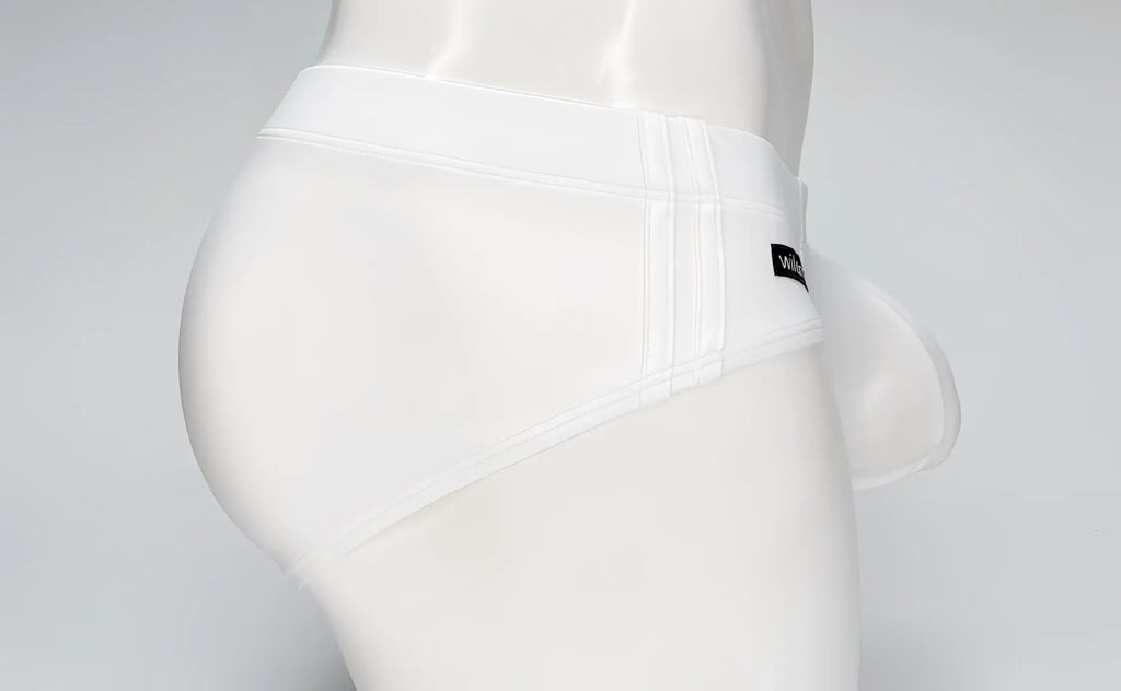 White WildmanT Big Boy pouch swim brief on a mannequin, side view showing a wide waistband and logo tag.