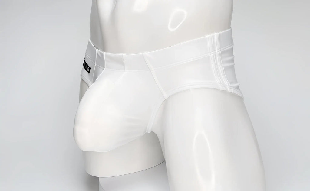 White WildmanT swim brief on a mannequin, featuring a contoured, prominent front pouch and side branding tag.