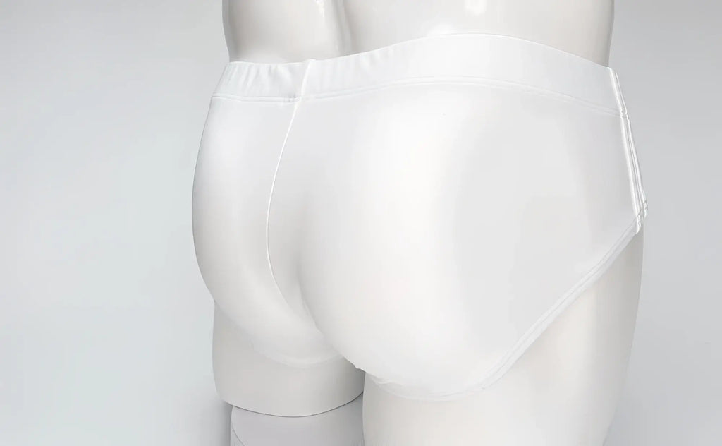 Back view of plain white WildmanT Big Boy swim brief on a mannequin, featuring a smooth, form-fitting design.