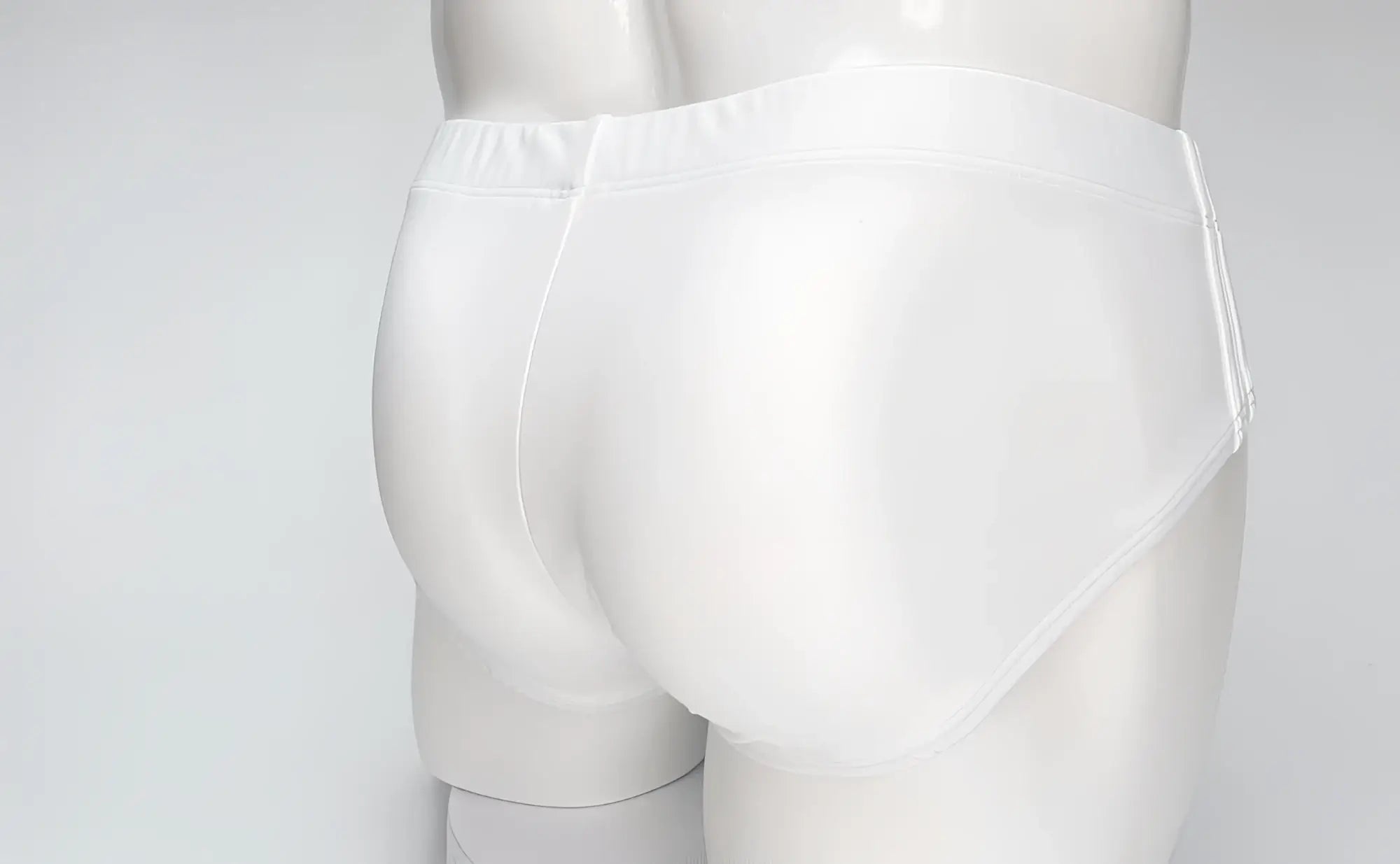 Back view of plain white WildmanT Big Boy swim brief on a mannequin, featuring a smooth, form-fitting design.