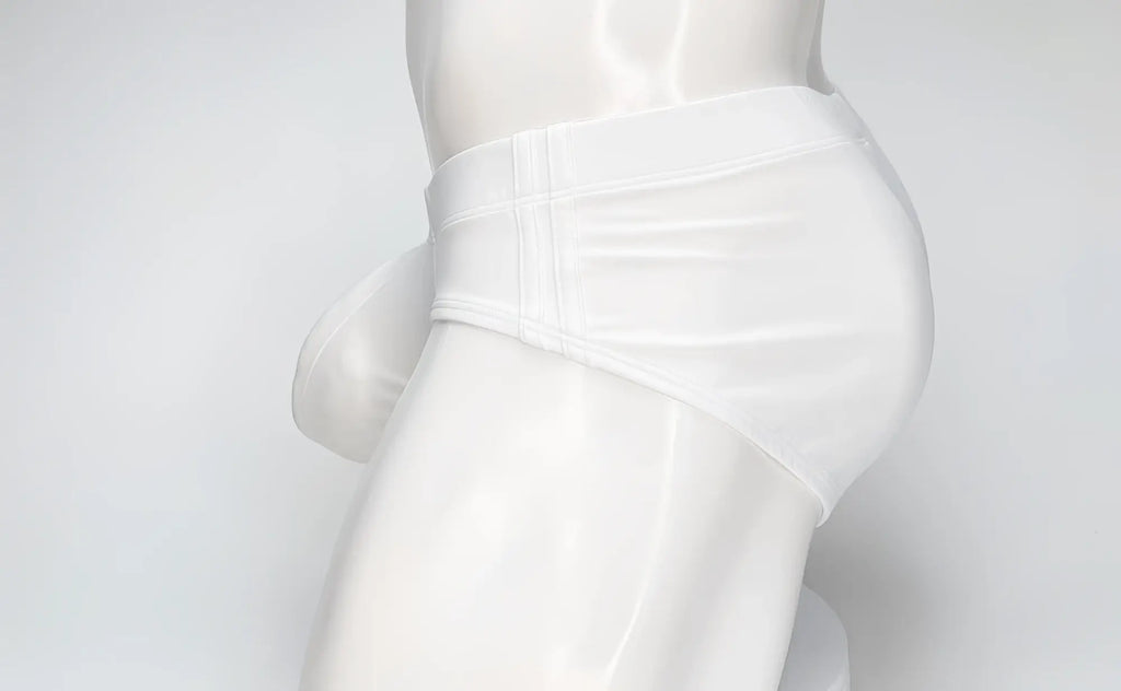 Side view of a white WildmanT swim brief with a prominent contoured pouch, worn on a white mannequin.