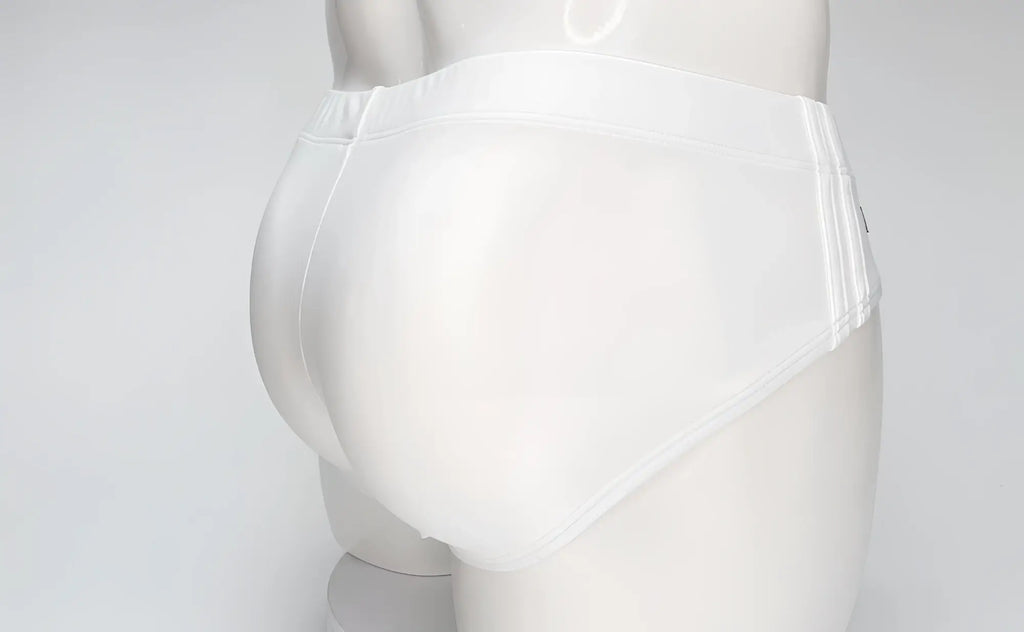 Back view of WildmanT white swim brief on a mannequin, featuring full coverage and elastic waistband.