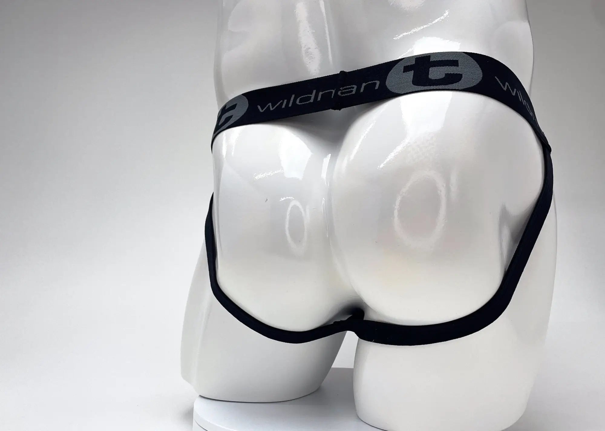 Red and black striped jockstrap with a black waistband featuring the white "WildmanT" logo on a white mannequin.