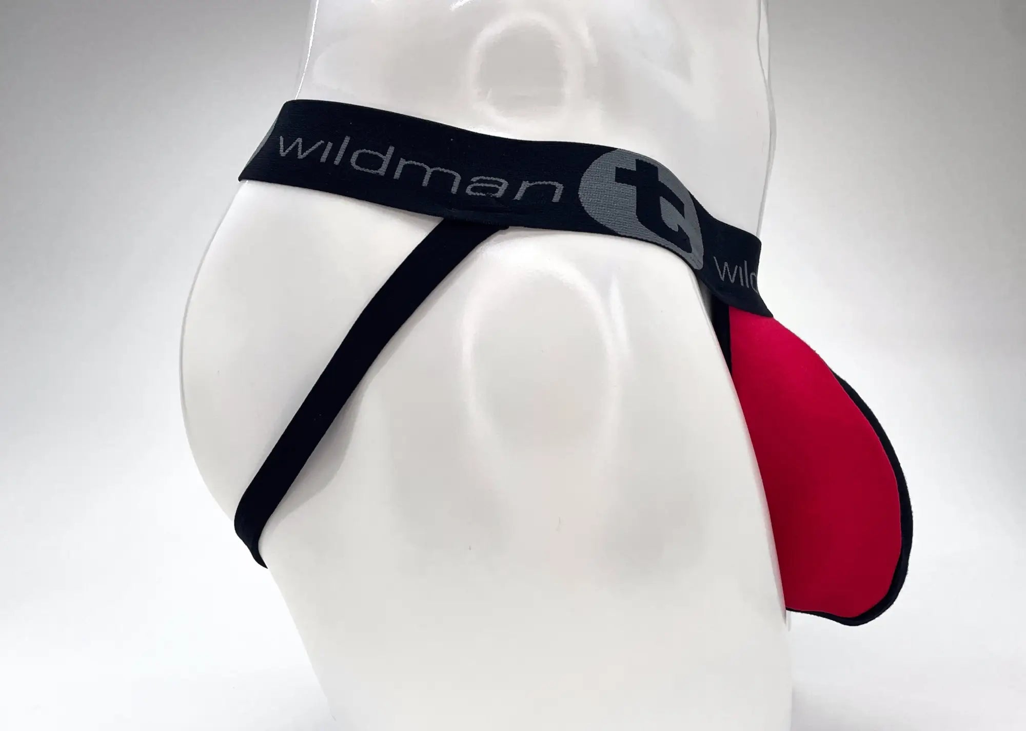 WildmanT jockstrap on a mannequin, featuring a red Big Boy pouch, black straps, and a branded black elastic waistband.