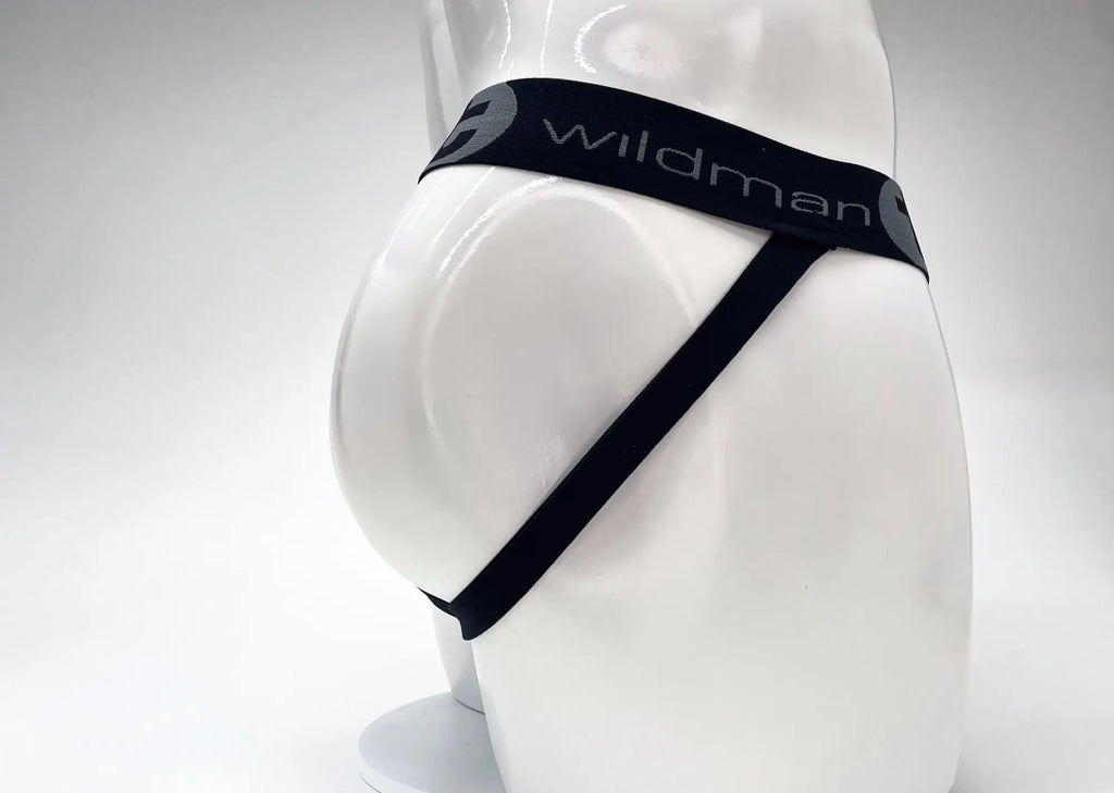 Side view of a red and black jockstrap with a black waistband featuring white "wildman" logo text on a white mannequin.