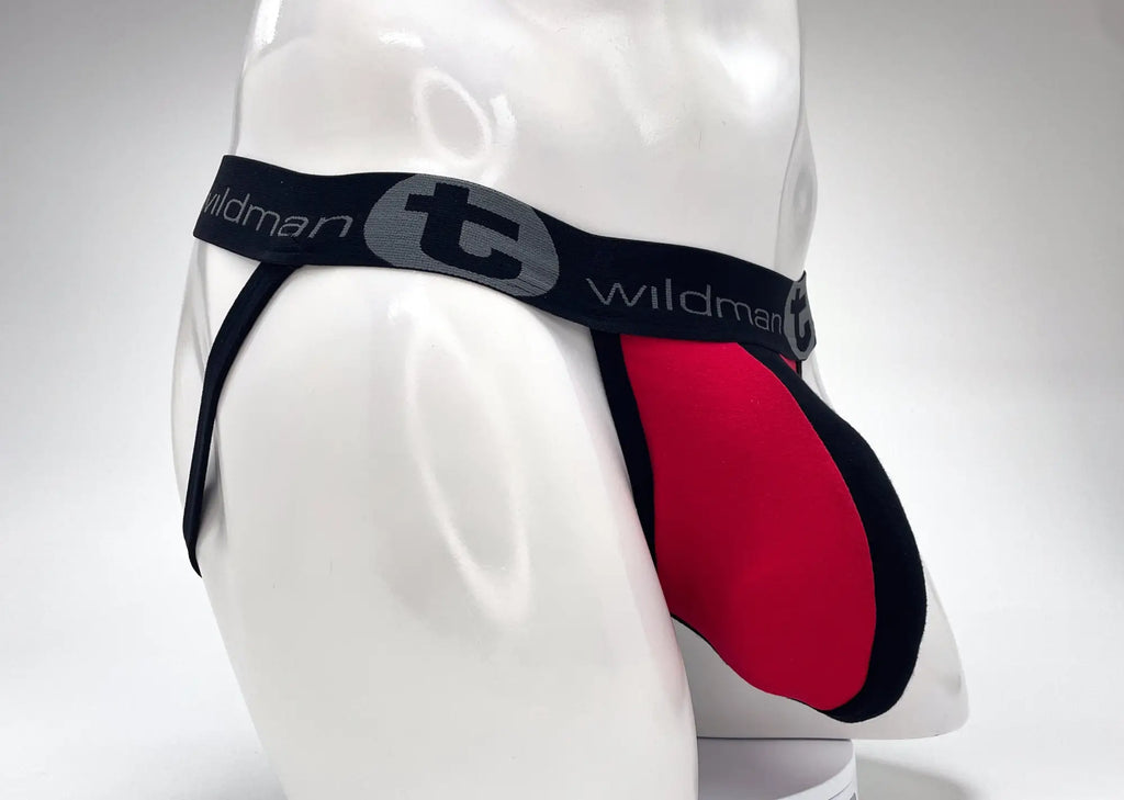 WildmanT red and black jockstrap on a mannequin, featuring a large pouch and branded elastic waistband.