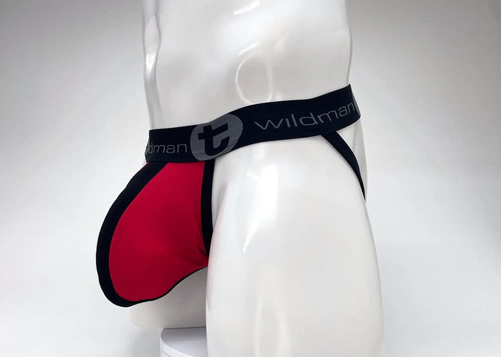 WildmanT jockstrap with red pouch, black trim, and wide black waistband with branded logo on a white mannequin torso.