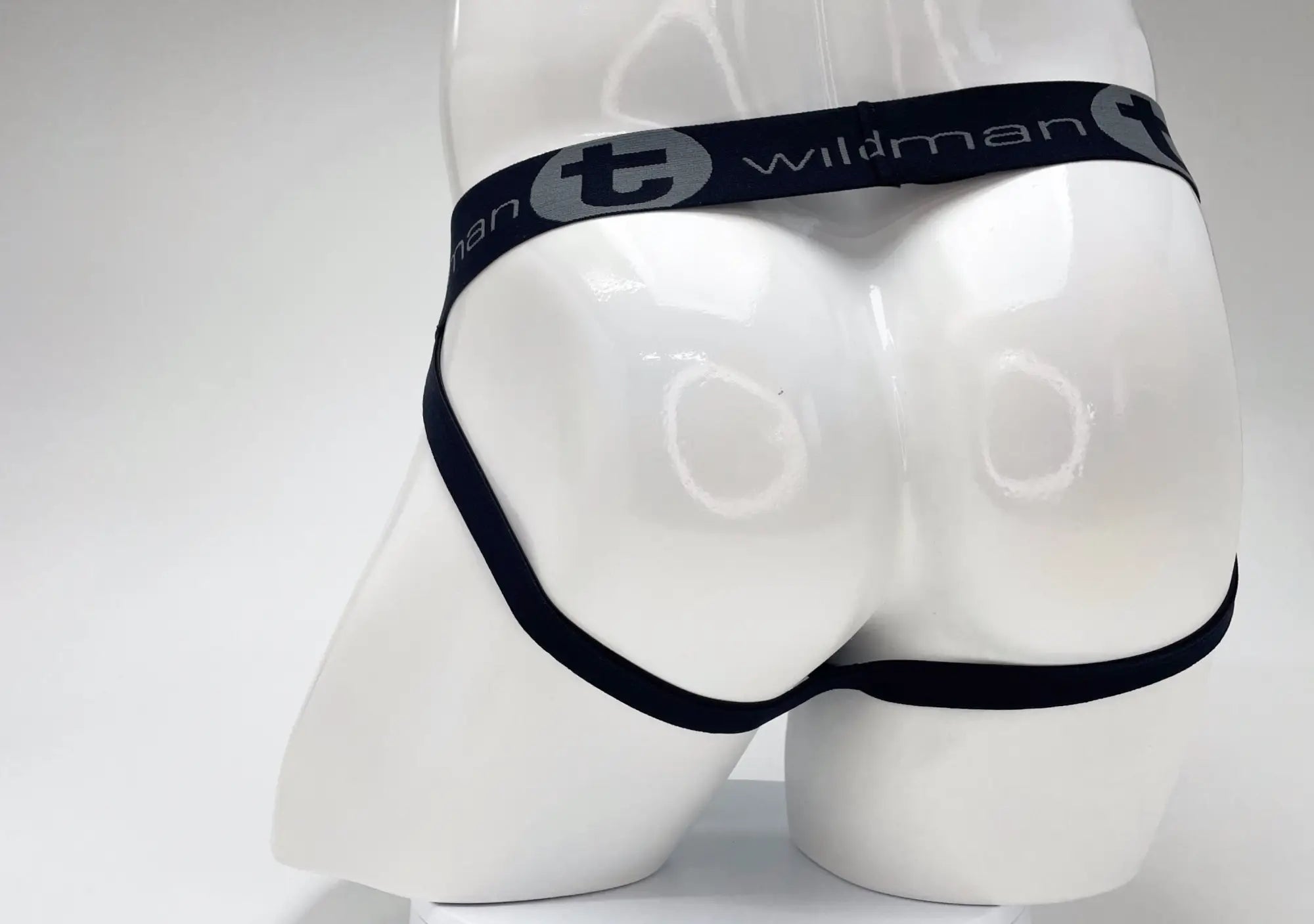 Back view of a WildmanT jockstrap on a mannequin, featuring a black waistband with gray logo text.