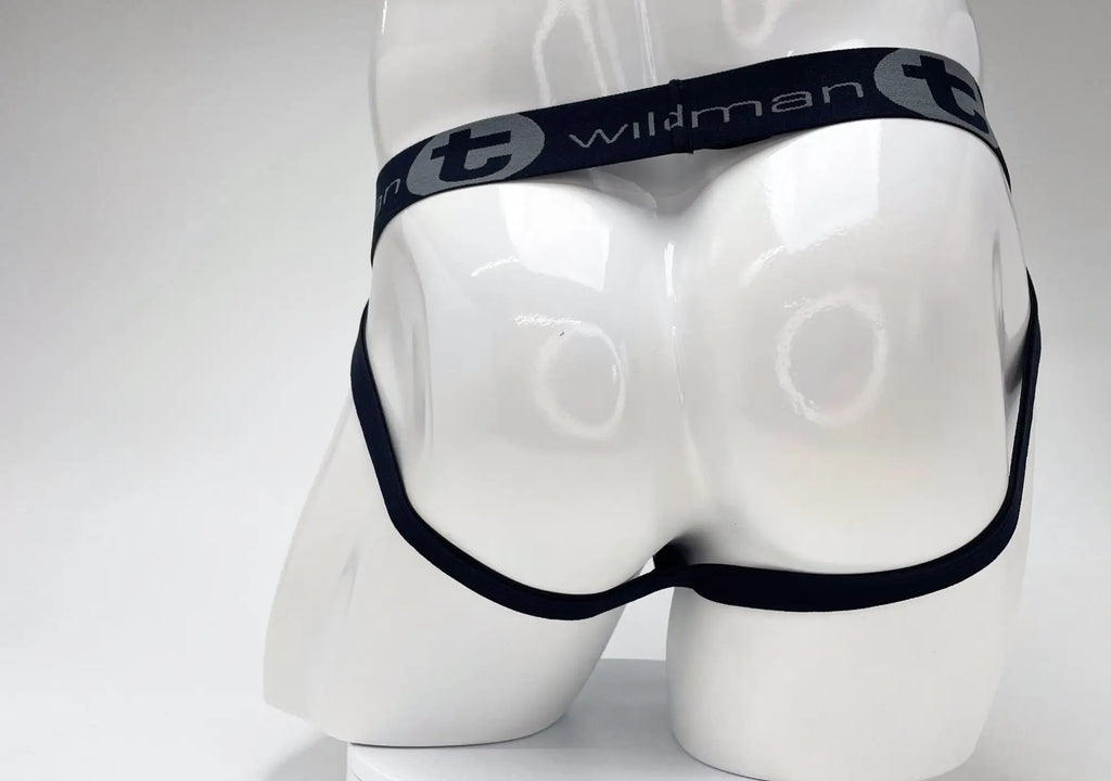 Rear view of a WildmanT jockstrap on a white mannequin featuring a black elastic waistband with grey logo branding.