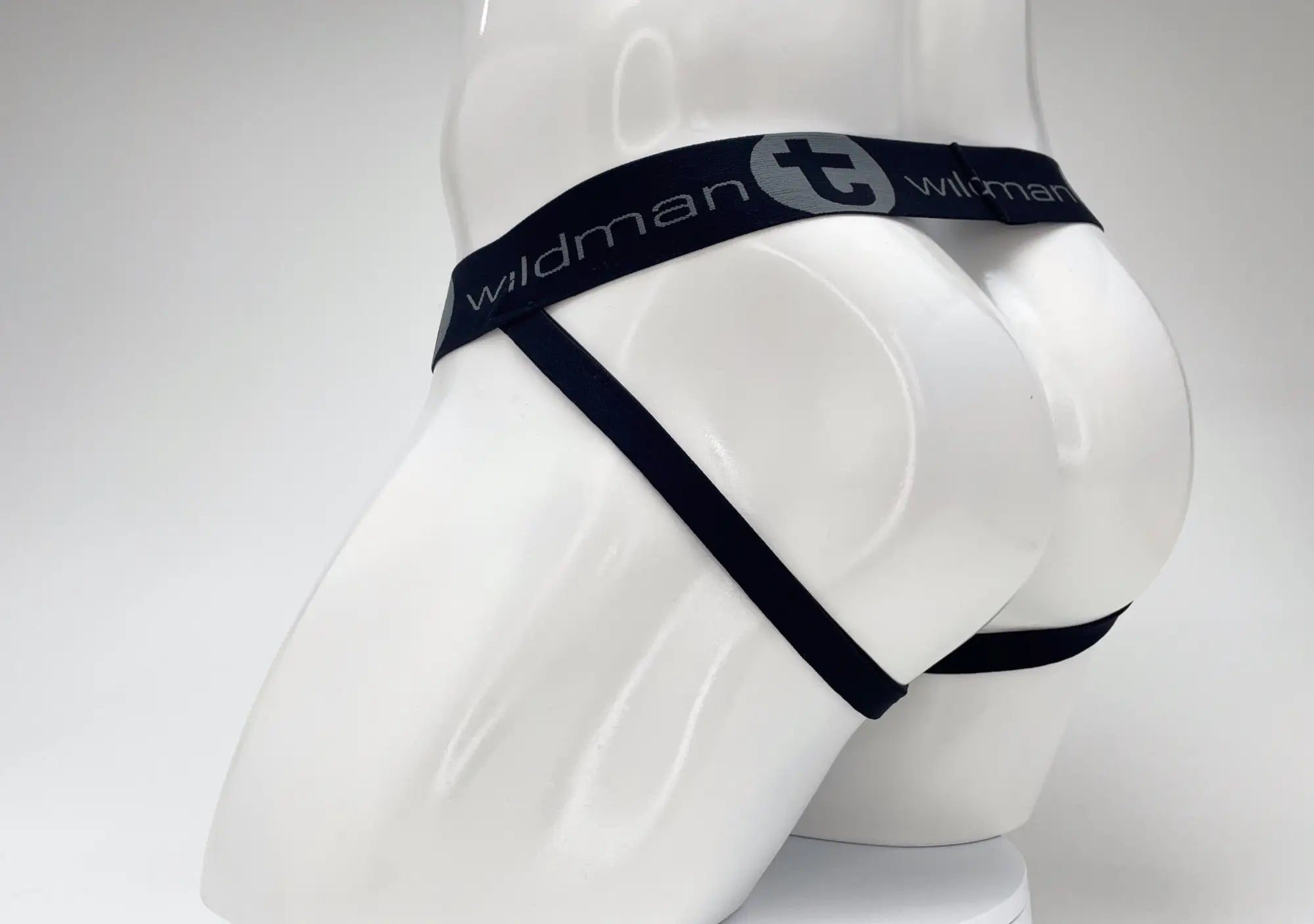 Dark navy jockstrap on a white mannequin, featuring a branded waistband with "WildmanT" logo.