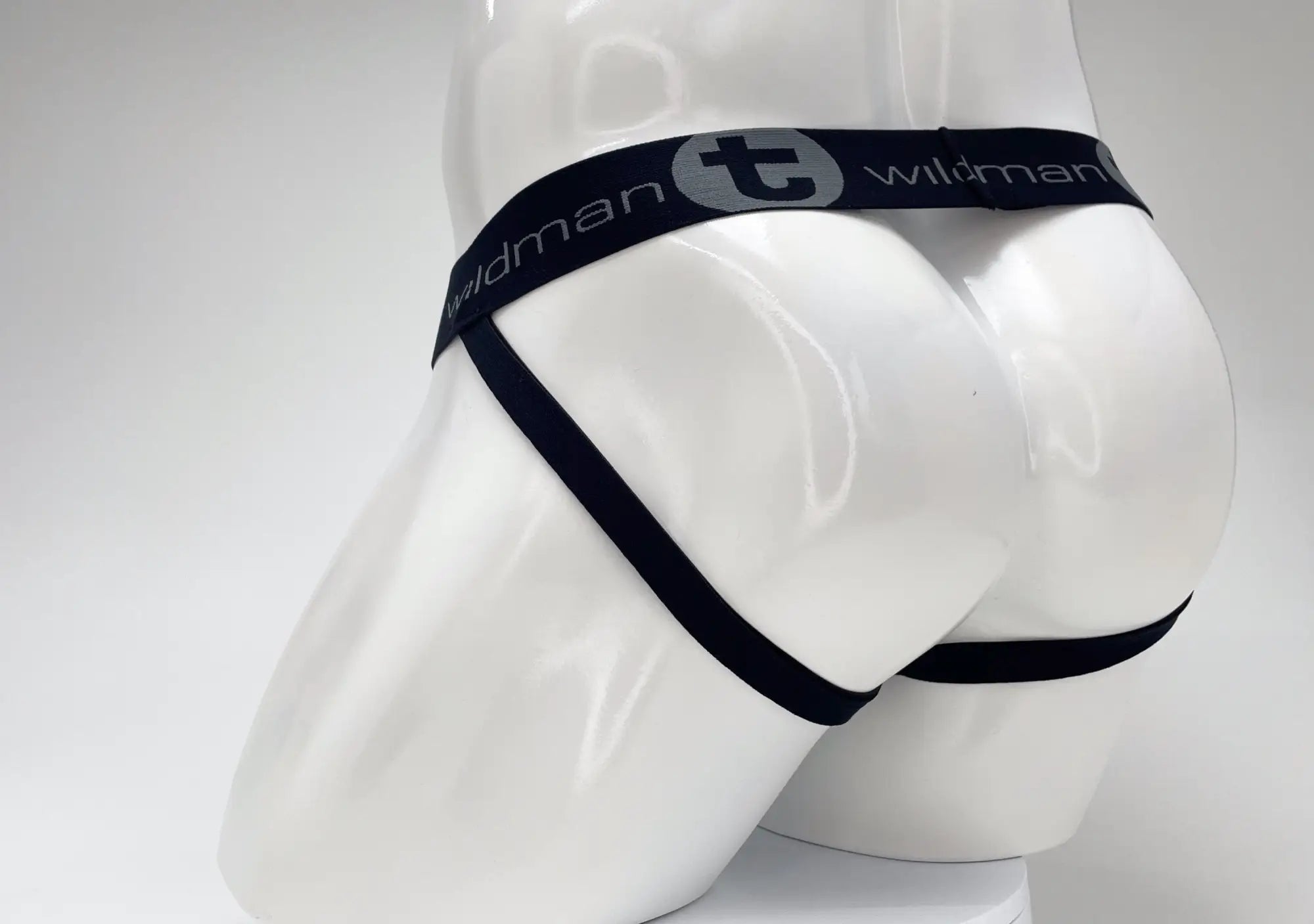 WildmanT jockstrap on a mannequin, featuring a black branded waistband and thin straps in a rear view.