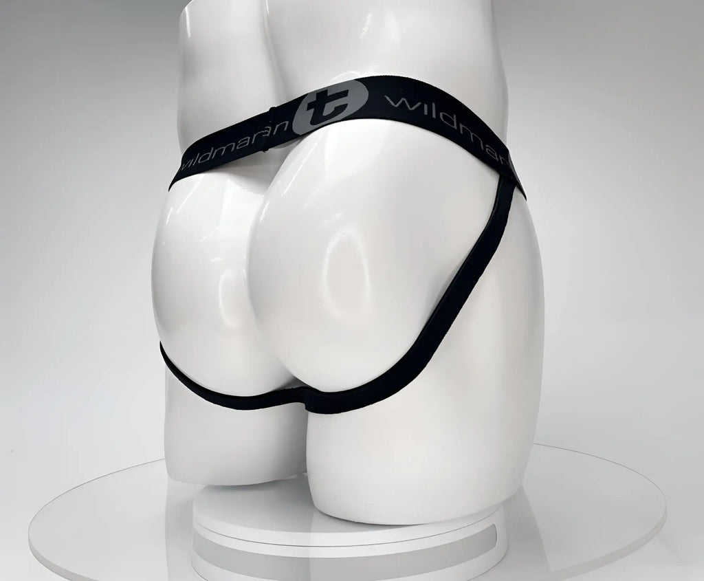 Back view of a black WildmanT jockstrap on a white mannequin, featuring a branded elastic waistband.