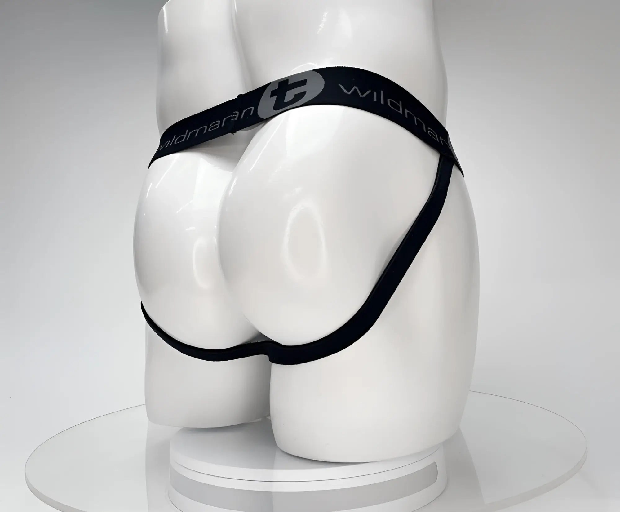 Back view of a black WildmanT jockstrap on a white mannequin, featuring a branded elastic waistband.