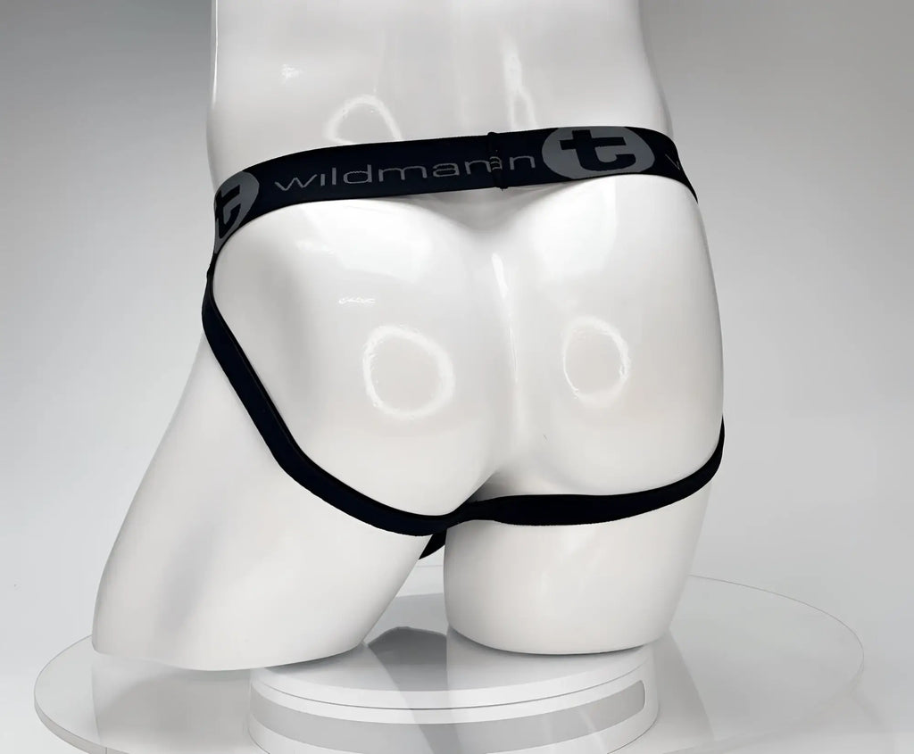 Back view of a black WildmanT jockstrap on a white mannequin, featuring a branded elastic waistband.