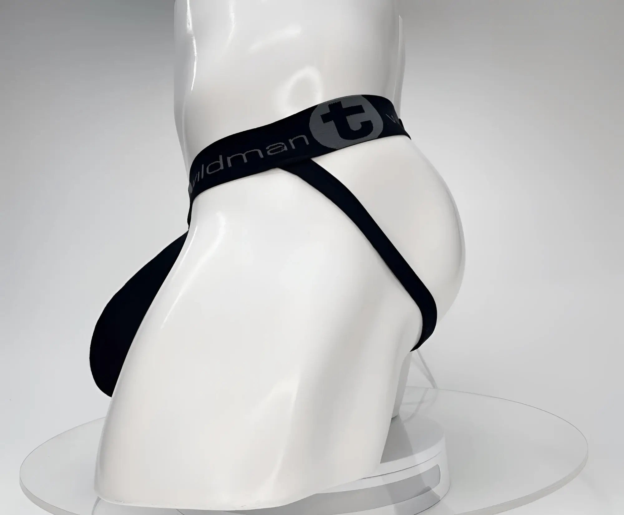 Black WildmanT cotton jockstrap on a white mannequin, featuring a branded elastic waistband with a "T" logo.