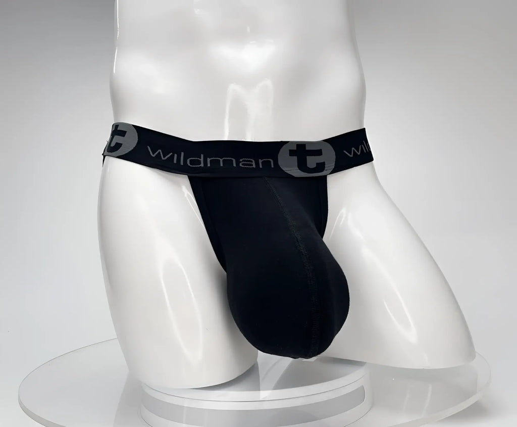 Black cotton jockstrap with a prominent pouch, worn on a mannequin, featuring a branded WildmanT elastic waistband.