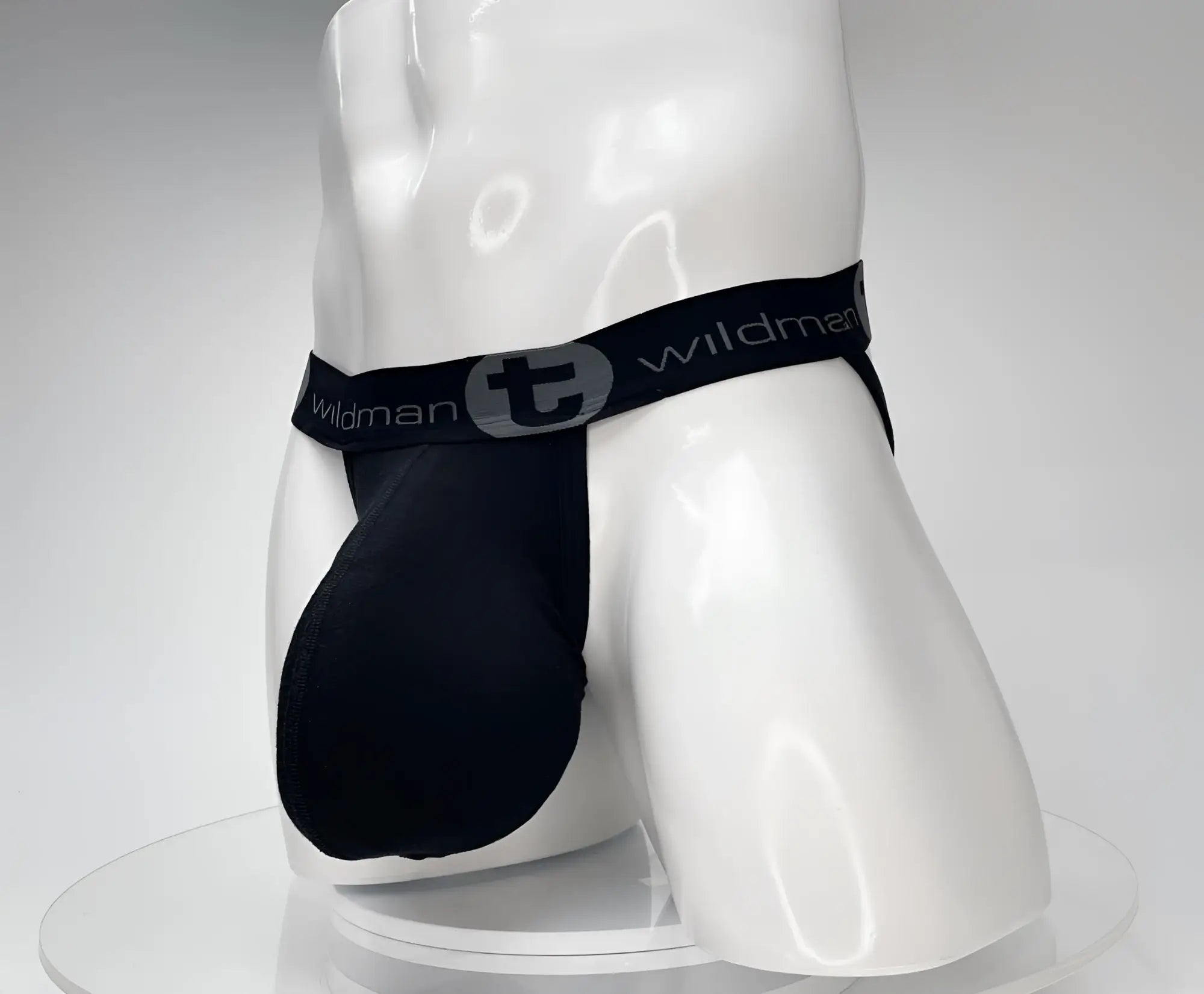 Black WildmanT cotton jockstrap with a contoured front pouch and branded black waistband on a white mannequin torso.