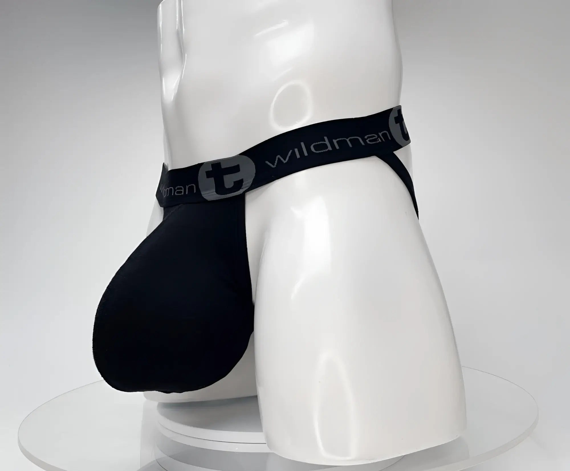 Black cotton jockstrap with a large pouch, shown on a white mannequin featuring a branded elastic waistband.